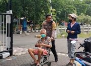 Layani Masyarakat yang Ingin Mencoblos, Kapolsek Gunung Anyar Bantu Dorong Kursi Roda Seorang Lansia